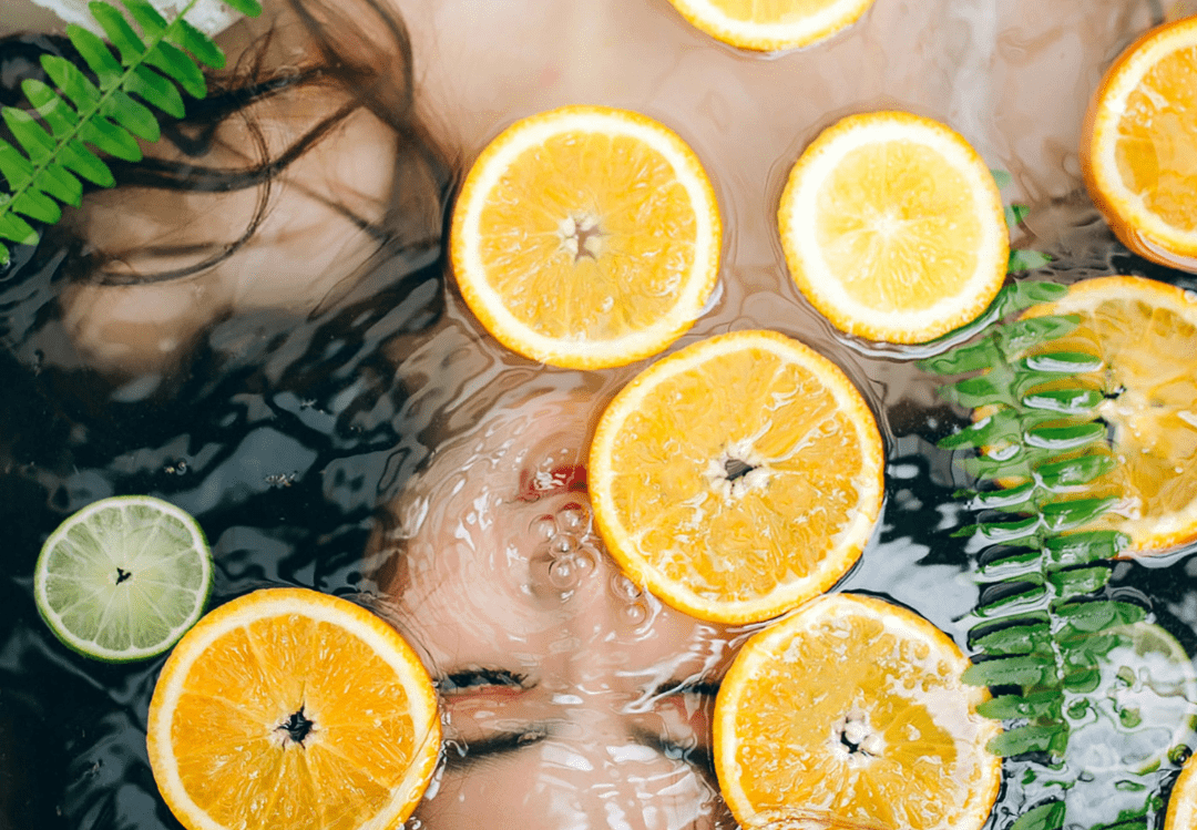 une femme sous l'eau avec des oranges